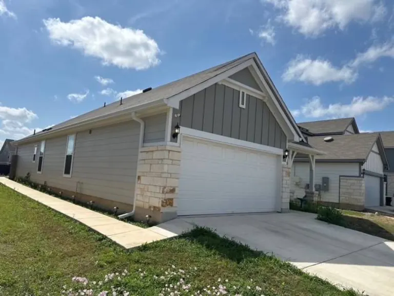 Seamless gutters along the roofline of a stone and siding home