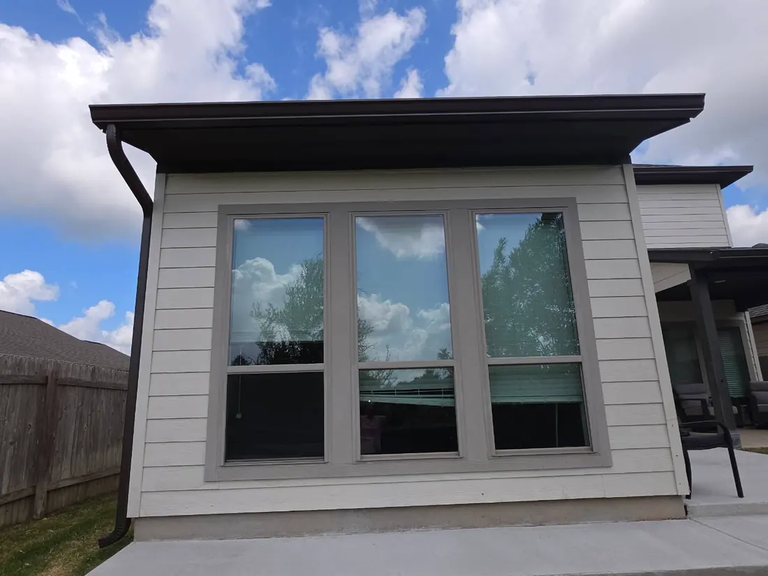 Bronze seamless gutter and downspout on a light-sided home