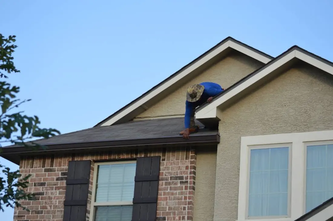 TX Gutter Expert installer fitting seamless gutter along a roof edge