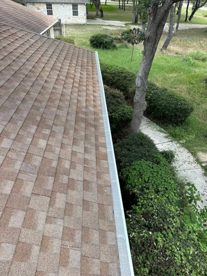 Seamless gutter running the length of a shingled roof edge