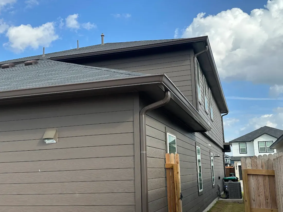 Finished bronze seamless gutter and downspout on a completed installation
