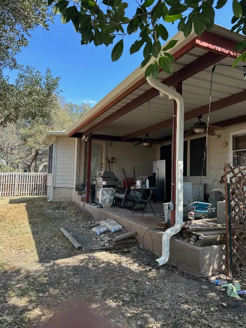 Downspout running down a covered porch on a ranch home