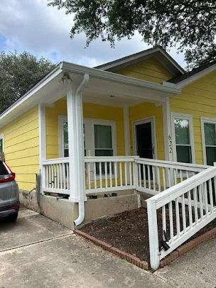 Seamless gutters on a yellow cottage with a front porch