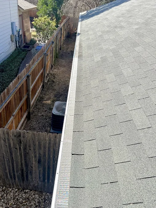 Gutter running along a shingled roof edge
