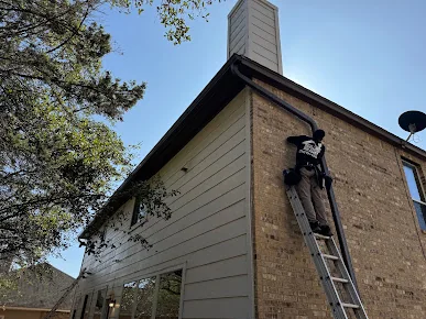 Ladder against a two-story home during a gutter installation